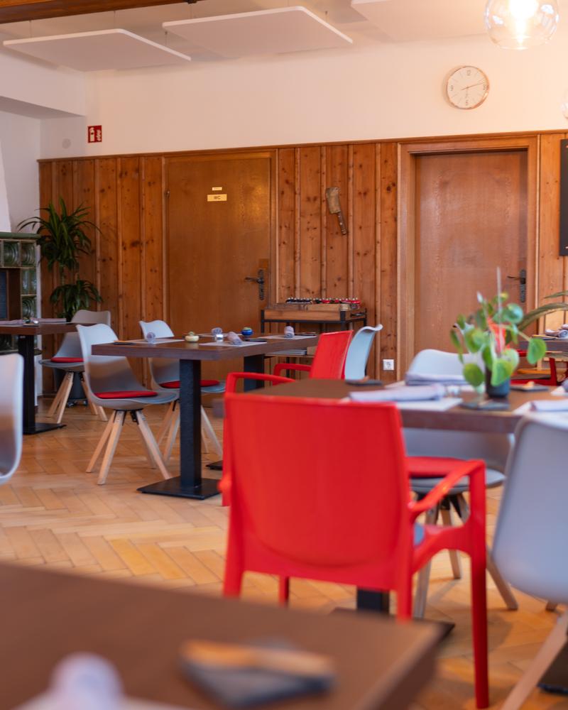 Gastraum mit grünem Kachelofen und Tafel mit hausgemachten Limonaden