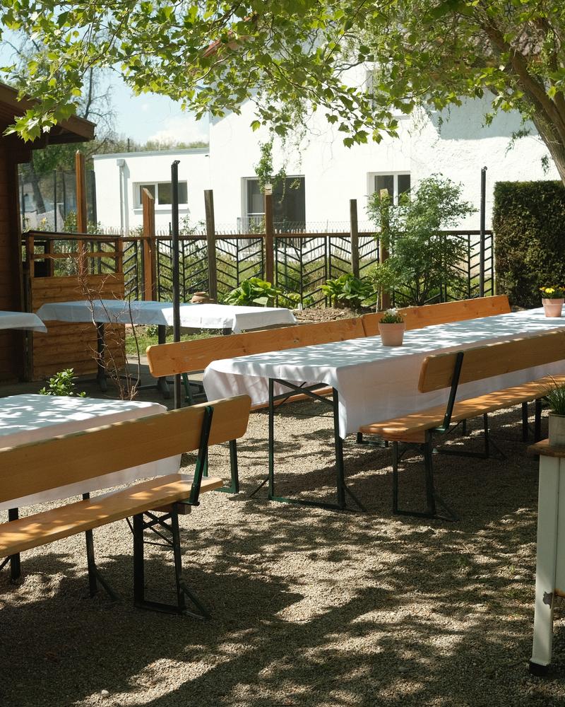 Gedeckte Biertische im Hof, daneben ein alter Emailleherd